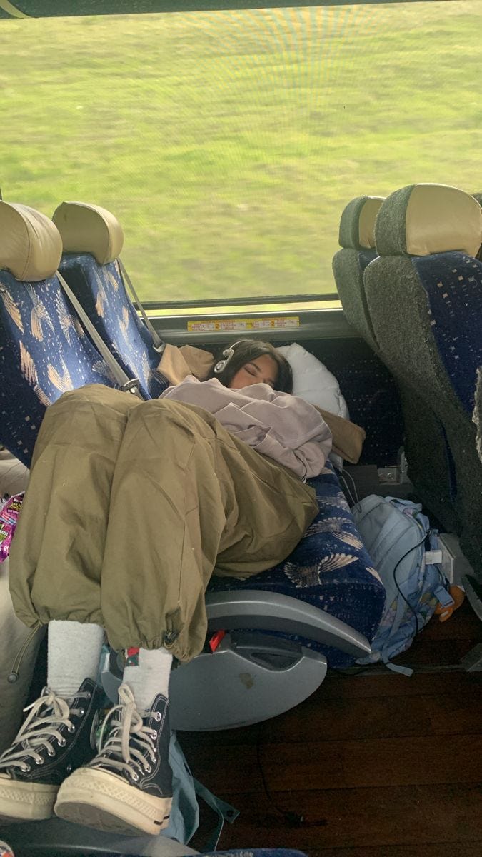 This may contain: a person sleeping in the back seat of a bus