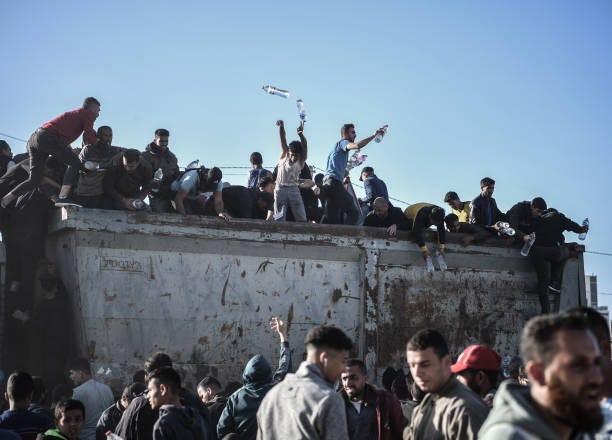 Palestinians flock to a truck carrying drinkable water, as they face the threat of hunger and thirst in Rafah, Gaza on December 11, 2023.