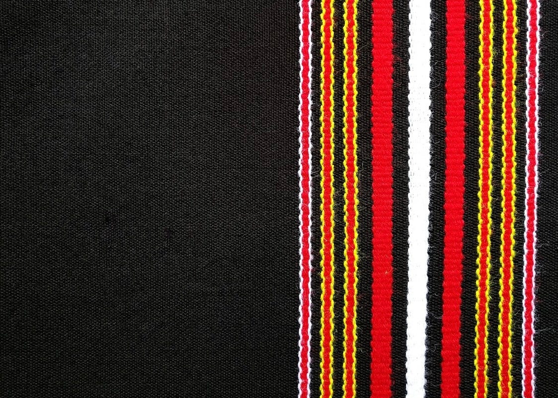 A richly woven shawl with intricate patterns and bold bands, representing the Tawlhlohpuan textile tradition of the Mizo community in Mizoram, India. A woven shawl with intricate patterns and bold bands, representing the Tawlhlohpuan textile tradition of the Mizo community in Mizoram, India. A richly woven shawl with intricate patterns and bold bands, representing the Tawlhlohpuan textile tradition of the Mizo community in Mizoram, India. A woven shawl with intricate patterns and bold bands, representing the Tawlhlohpuan textile tradition of the Mizo community in Mizoram, India.