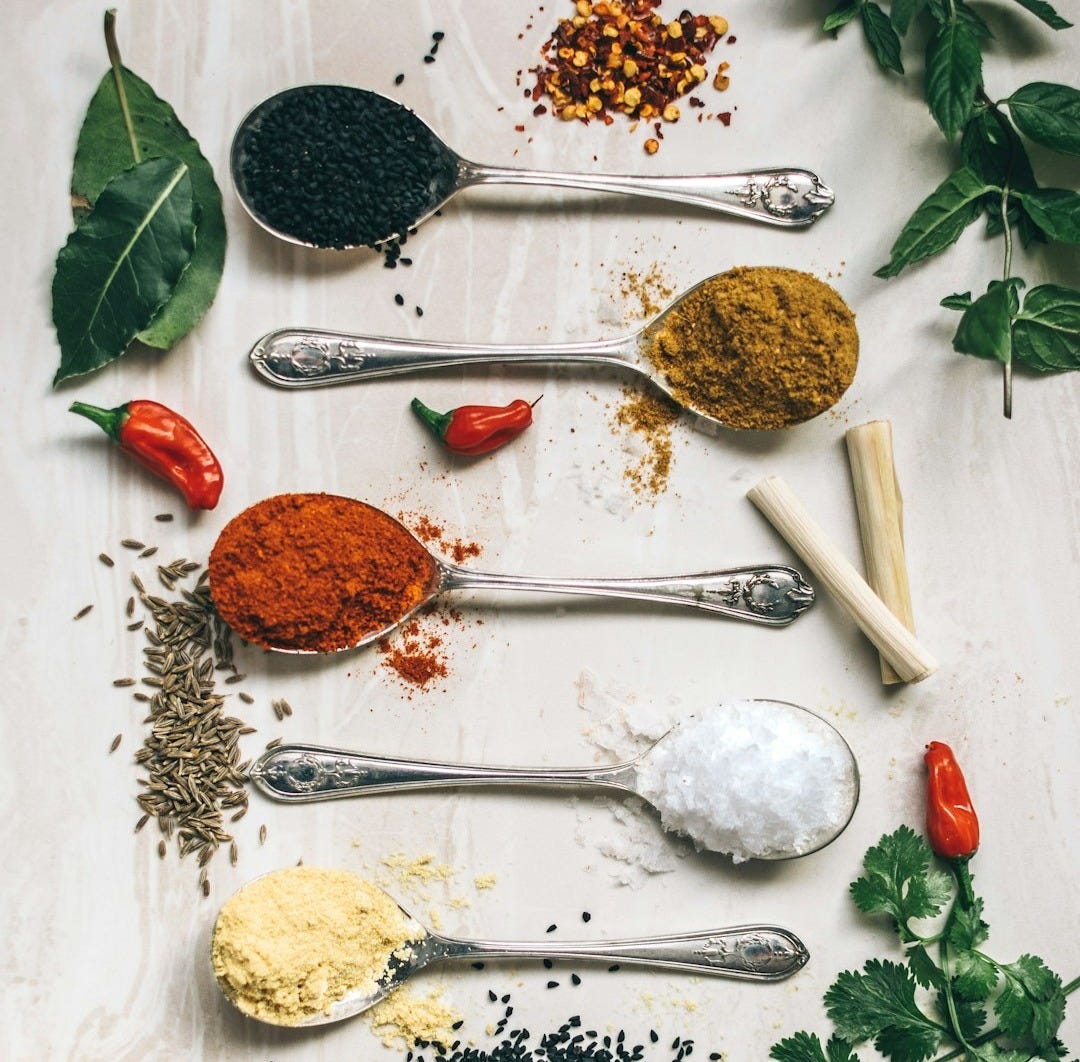 five gray spoons filled with assorted-color powders near chilli five gray spoons filled with assorted-color powders near chilli