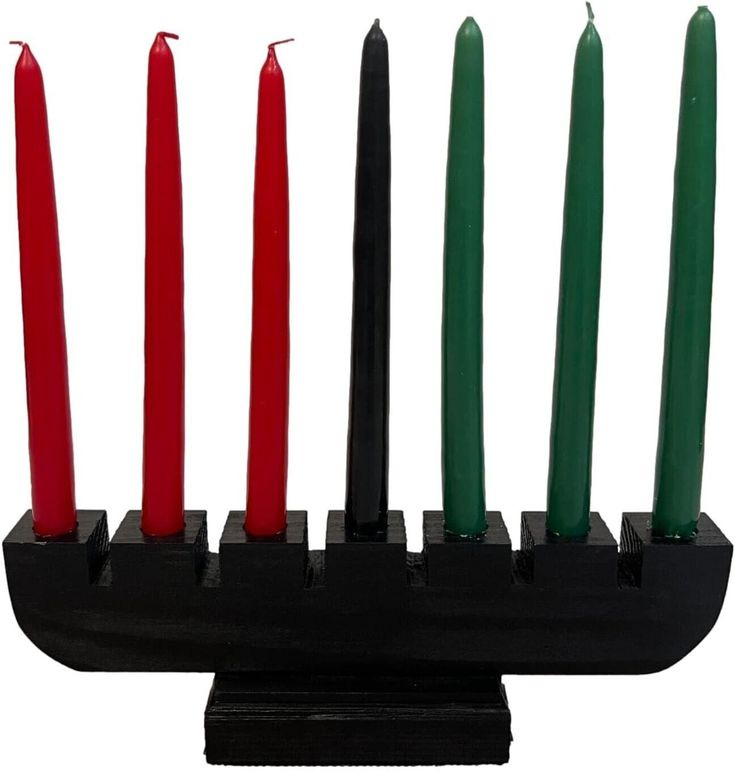 This may contain: four red and green candles in a black holder
