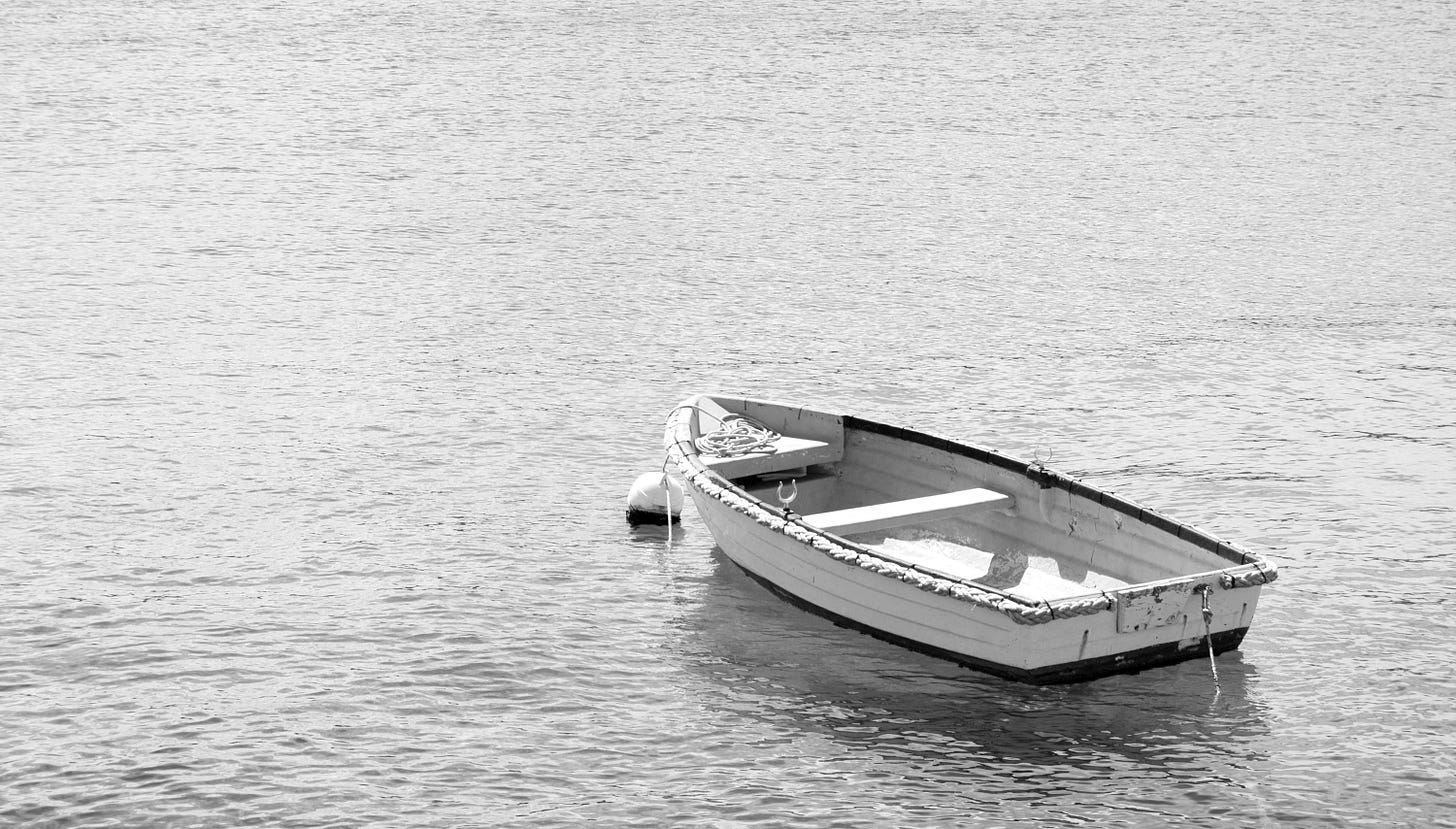 white and brown wooden boat on body of water during daytime white and brown wooden boat on body of water during daytime