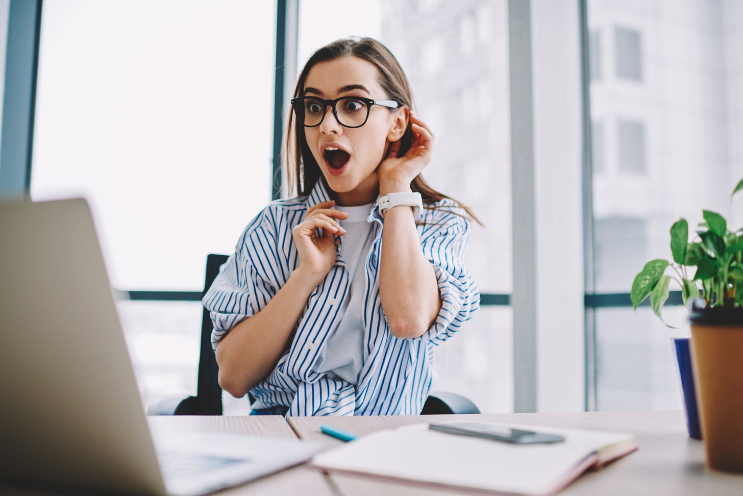 Hipster woman with surprised reaction to computer screen Hipster woman with surprised reaction to computer screen