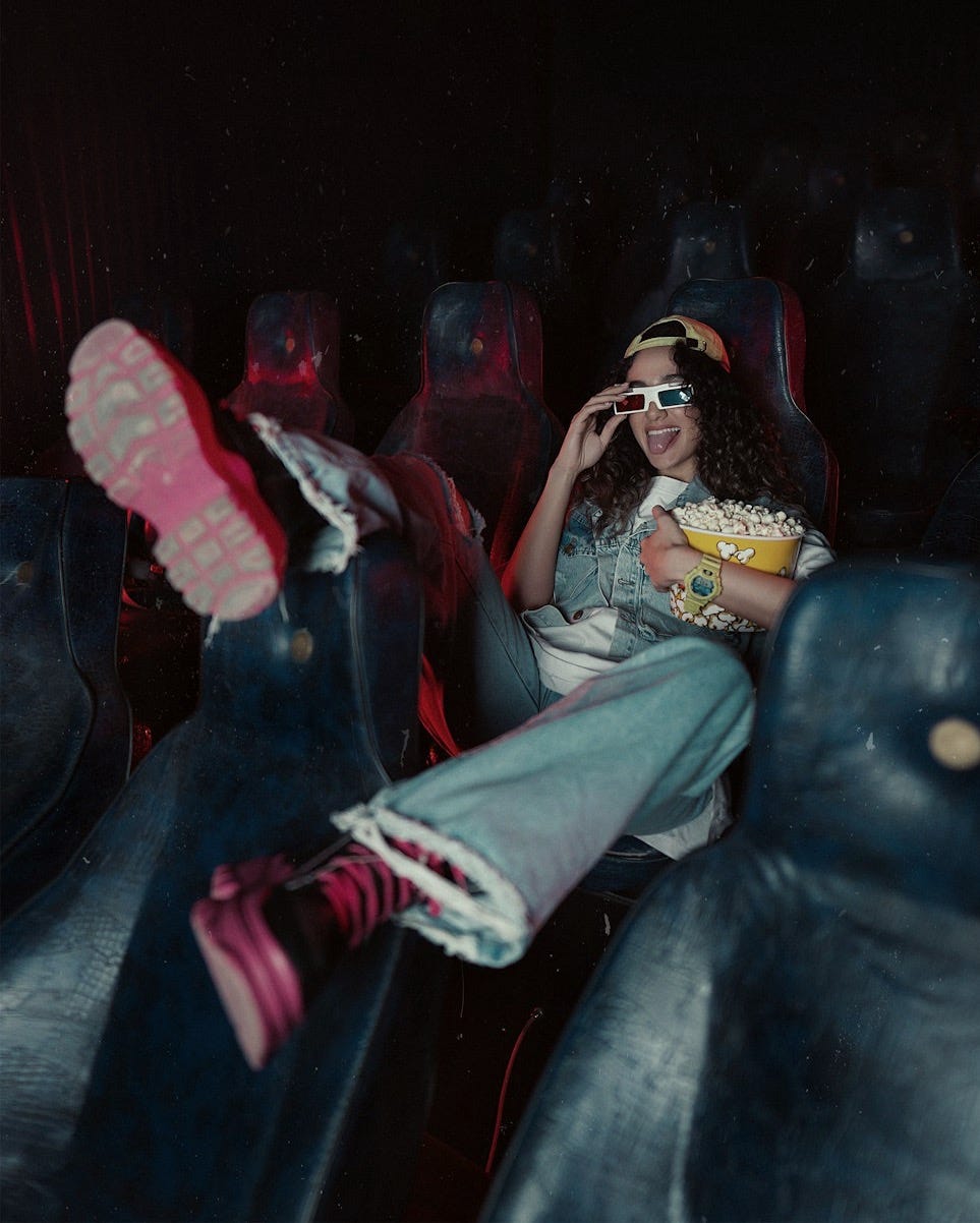 a woman sitting in the middle of a movie theater a woman sitting in the middle of a movie theater