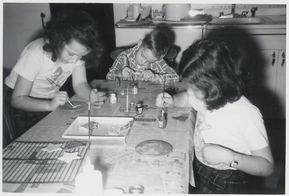 Three children painting ornaments