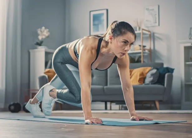 Woman performing a burpee or mountain climbers at home on a yoga mat. Woman performing a burpee or mountain climbers at home on a yoga mat.