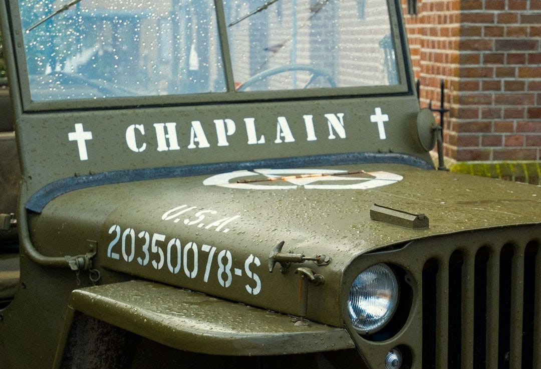 a green jeep parked in front of a brick building