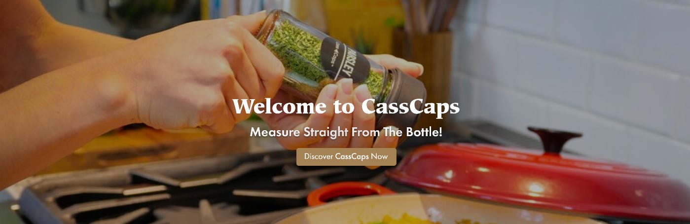 Hands sprinkling herbs from a CassCaps storage jar with a measuring cap into a red pot on a stove. Welcome to CassCaps, making it easy to measure seasonings right through the cap without opening the storage jar. Measure Straight From The Bottle! Discover CassCaps Now.