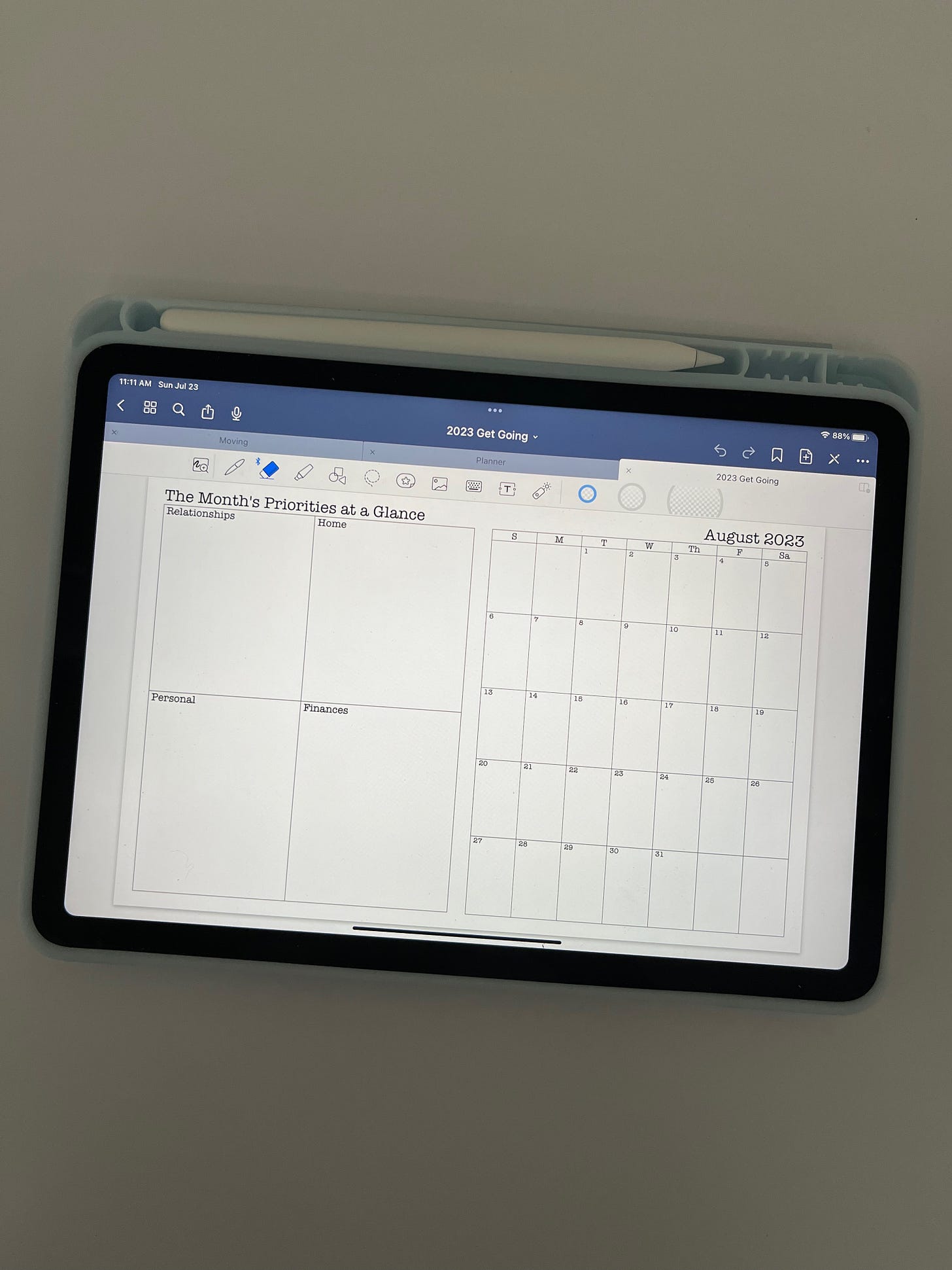 ipad with planner loaded in a blue case with ipencil.