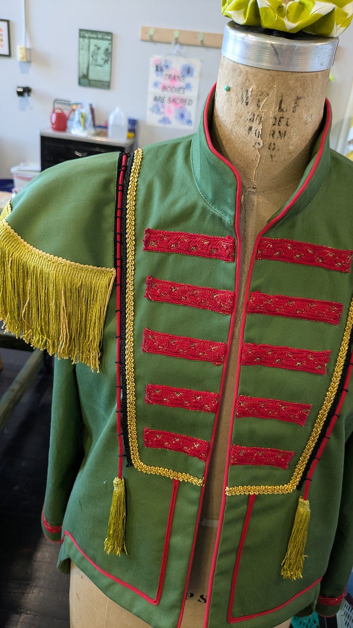 a close up of a costume jacket using paracord as trim, botanical cyanotypes drying