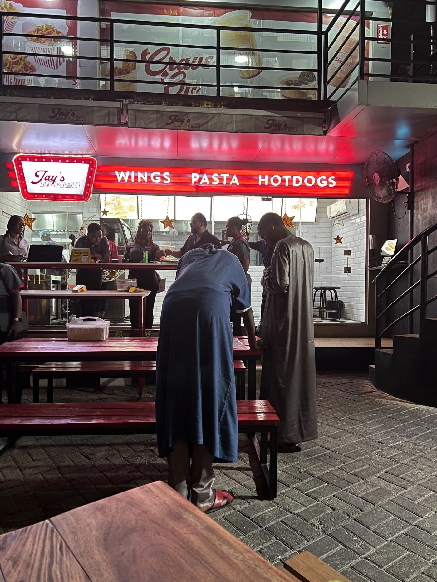 Customers looking at the menu while the waiters wait on them. Photo by Osioke Itseuwa.
