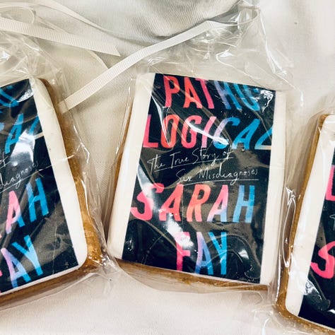 Flowers and a woman behind them, two images of book covers, cookies with the image of Pathological on them
