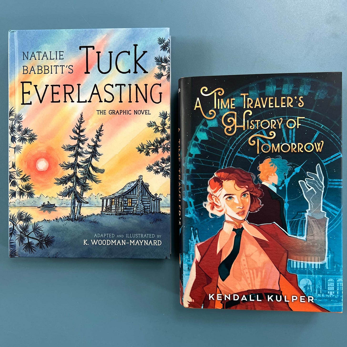 Photographs of the printed copies of graphic novelist K. Woodman-Maynard’s graphic novel adaptation of Tuck Everlasting and Kendall Kulper’s novel A Time Traveler’s History of Tomorrow. Photographs of the printed copies of graphic novelist K. Woodman-Maynard’s graphic novel adaptation of Tuck Everlasting and Kendall Kulper’s novel A Time Traveler’s History of Tomorrow.