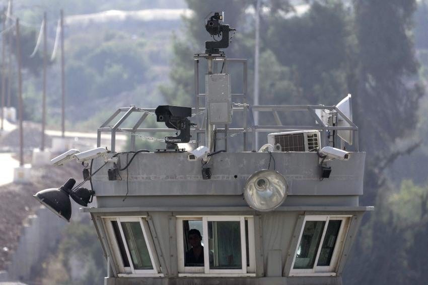 Two guns sit atop a guard tower along with surveillance cameras overlooking the Aroub refugee camp in the Israeli-occupied West Bank, October 6, 2022. 