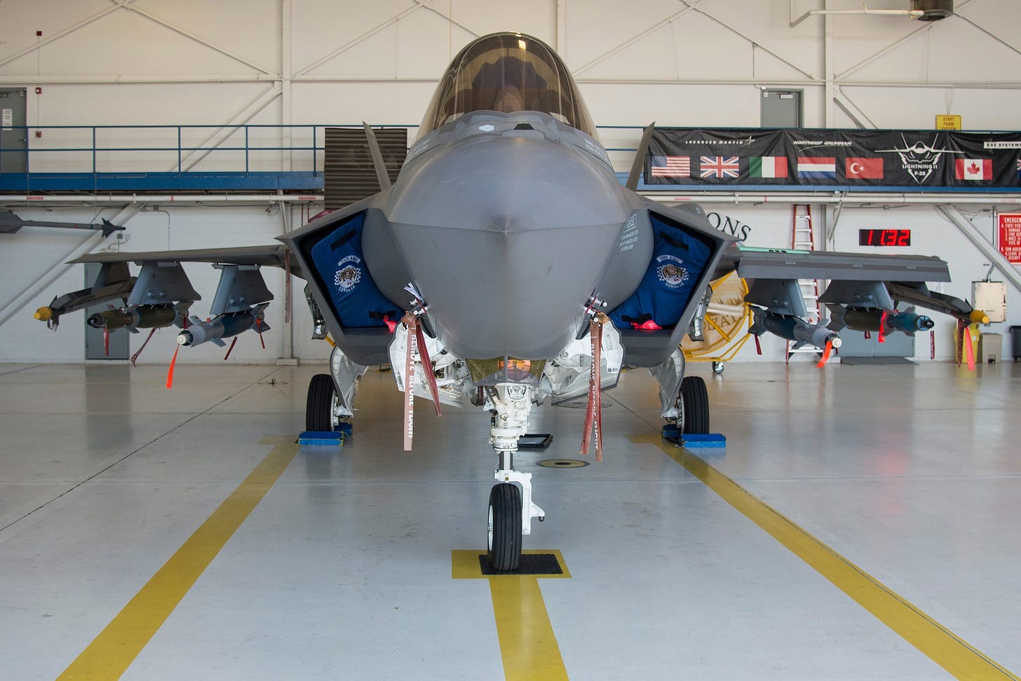 Maintainers loading an F-35A through its open internal weapons bays at Eglin Air Force Base.