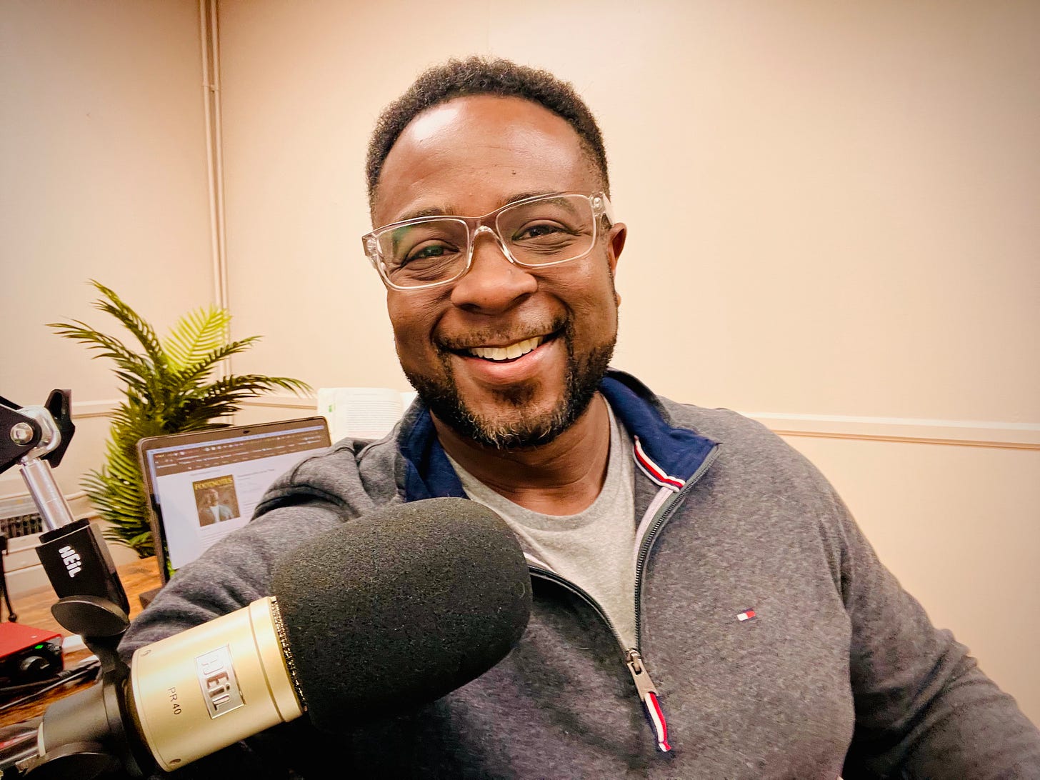 Photo of Jemar Tisby sitting in an office with a microphone in front of him