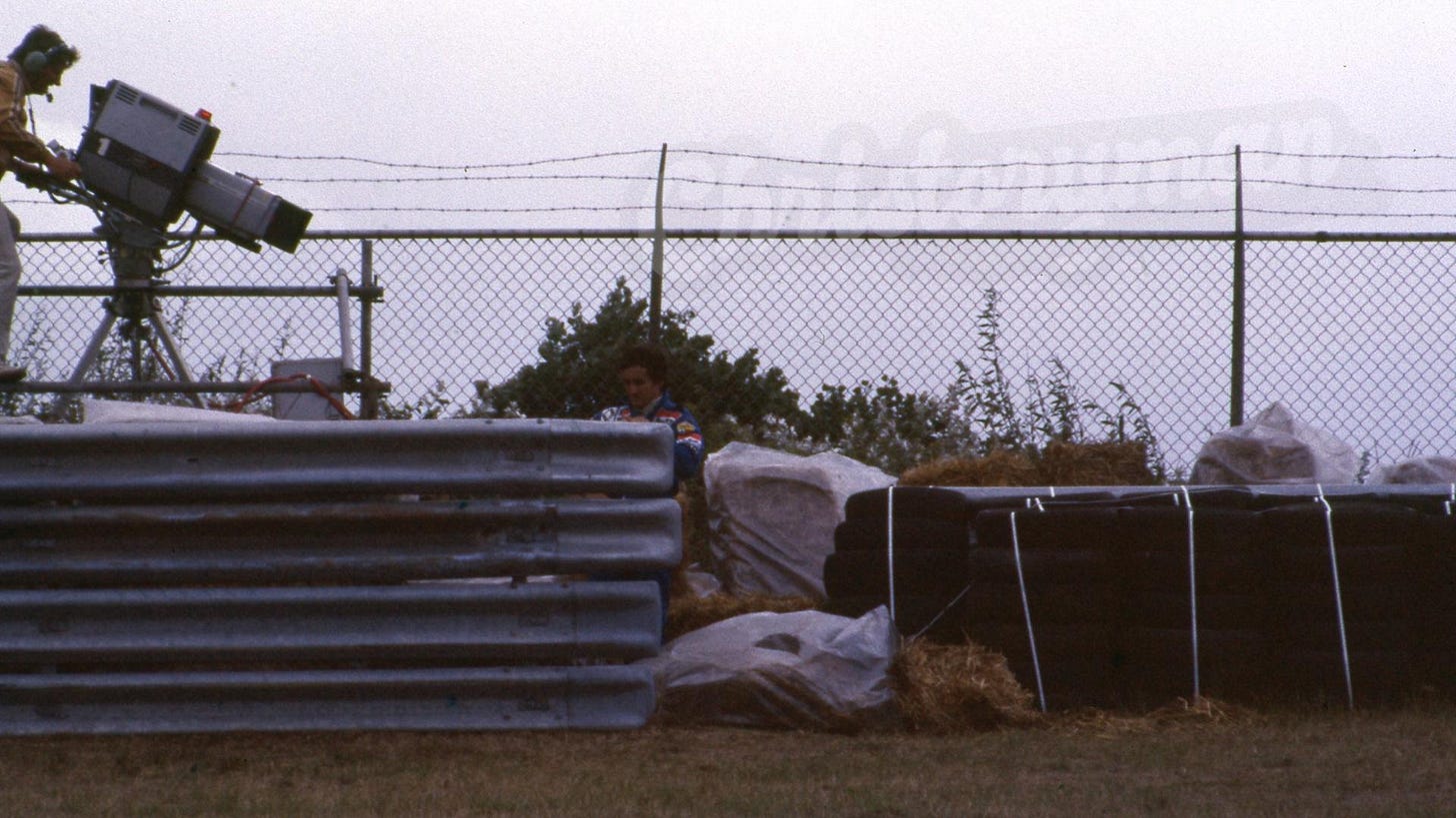 Alain Prost can't escape the TV camera after retiring from the 1983 Dutch Grand Prix in Zandvoort, following a collision with Nelson Piquet. A cameraman films him from a platform beside the track. A small but iconic piece of Formula 1 history. Alain Prost can't escape the TV camera after retiring from the 1983 Dutch Grand Prix in Zandvoort, following a collision with Nelson Piquet. A cameraman films him from a platform beside the track. A small but iconic piece of Formula 1 history.