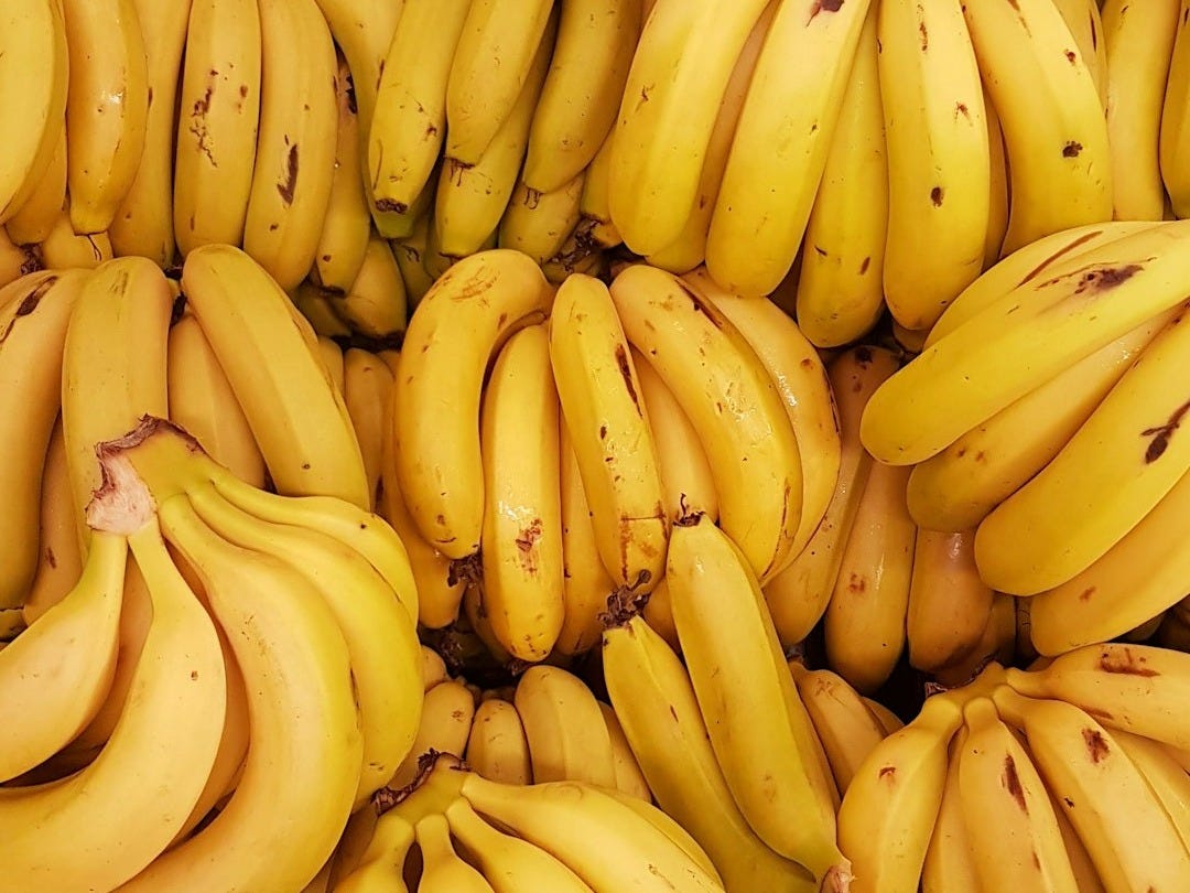 yellow banana fruit on brown wooden table