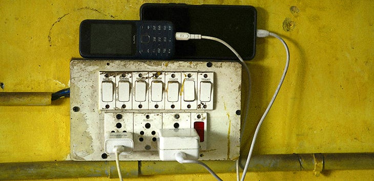 Photo of an old set of power sockets charging a couple of old smartphones.