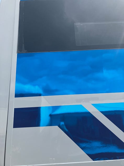 Smooth and shiny electric blue; close-up of a post-race car tyre; a big puffy pop-up building