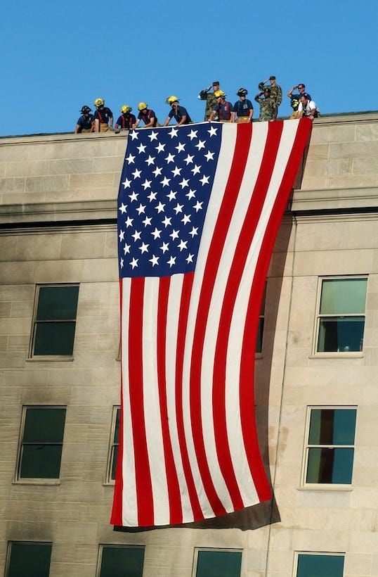 Military service members salute as fire and rescue workers unfurl a huge American flag over the side of the damaged Pentagon, Sept. 12, 2001, during rescue and recovery efforts following the previous day’s terrorist attack. At about 9:40 a.m. local time, a hijacked commercial airliner, originating from Washington’s Dulles airport, was flown into the Pentagon’s western side. In his weekly address to the nation issued Sept. 10, 2016, President Barack Obama recalled the 9/11 attacks that struck the United States 15 years ago. He urged all Americans to honor the memory of the nearly 3,000 victims of the attacks that targeted the Twin Towers in New York City, the Pentagon, and another airliner that crashed into a Pennsylvania field. He also called on citizens to salute the efforts of the firemen, police and other first responders who risked their lives to help others in need that dark day, as well as the U.S. service members, diplomats, and the intelligence, homeland security and law enforcement professionals “who serve, and have given their lives, to help keep us safe.” Navy photo by Petty Officer 1st Class Michael W. Pendergrass Military service members salute as fire and rescue workers unfurl a huge American flag over the side of the damaged Pentagon, Sept. 12, 2001, during rescue and recovery efforts following the previous day’s terrorist attack. At about 9:40 a.m. local time, a hijacked commercial airliner, originating from Washington’s Dulles airport, was flown into the Pentagon’s western side. In his weekly address to the nation issued Sept. 10, 2016, President Barack Obama recalled the 9/11 attacks that struck the United States 15 years ago. He urged all Americans to honor the memory of the nearly 3,000 victims of the attacks that targeted the Twin Towers in New York City, the Pentagon, and another airliner that crashed into a Pennsylvania field. He also called on citizens to salute the efforts of the firemen, police and other first responders who risked their lives to help others in need that dark day, as well as the U.S. service members, diplomats, and the intelligence, homeland security and law enforcement professionals “who serve, and have given their lives, to help keep us safe.” Navy photo by Petty Officer 1st Class Michael W. Pendergrass