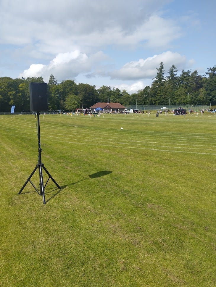 A sports field with a speaker to the left of the image