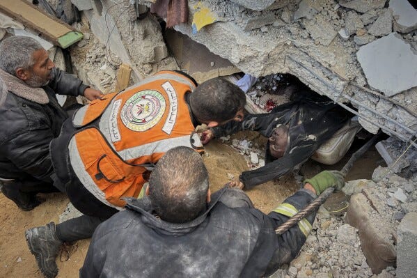 EDS NOTE: GRAPHIC CONTENT - Rescue workers and volunteers attempt to pull the body of a man from the rubble following an Israeli army airstrike in Khan Younis, southern Gaza Strip, Thursday, March 20, 2025. (AP Photo/Mariam Dagga, File)