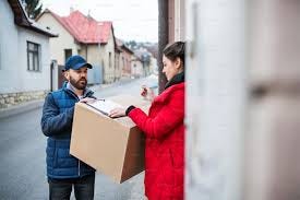 Young woman receiving parcel from ...