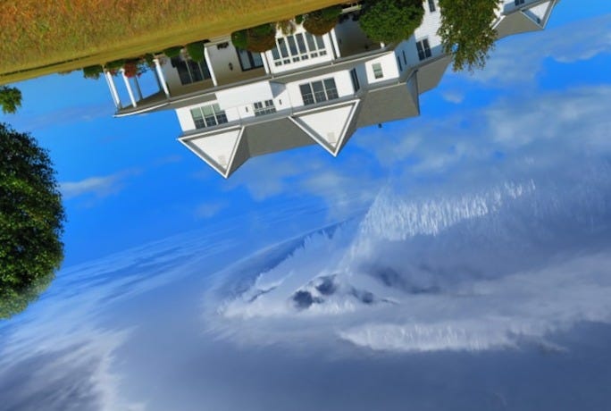 white and gray house between two green tall trees under gray clouds forming swirl during daytime