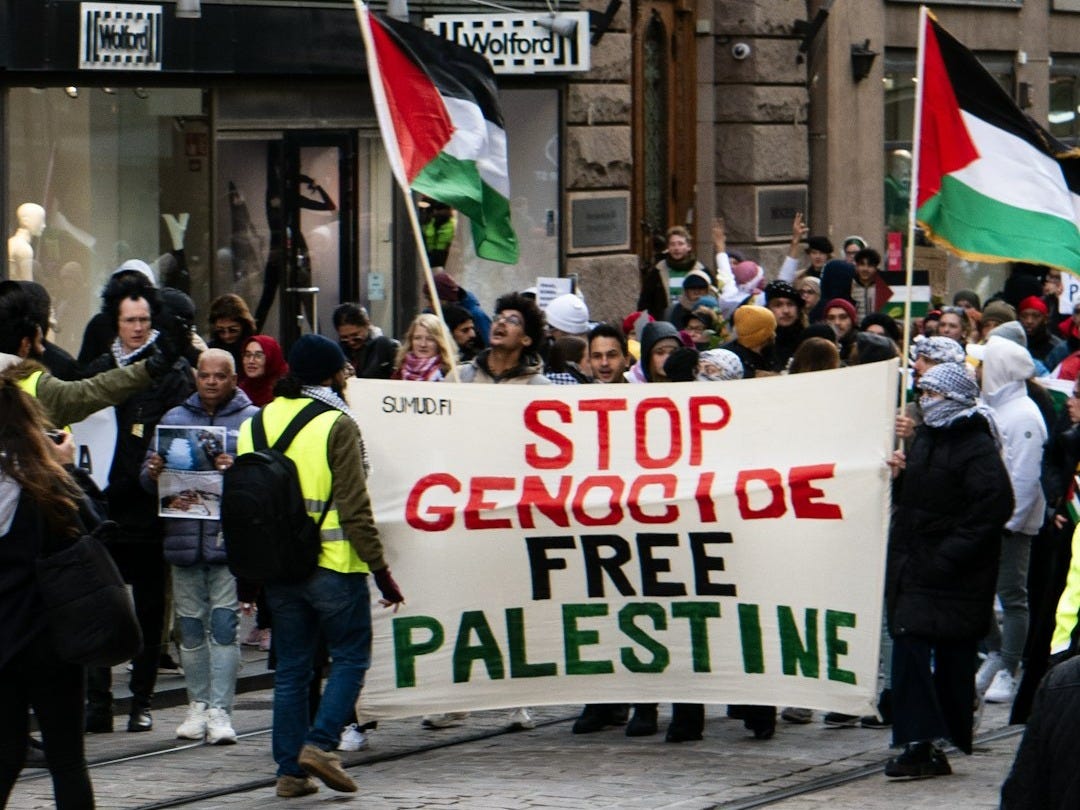 a group of people walking down a street holding flags a group of people walking down a street holding flags