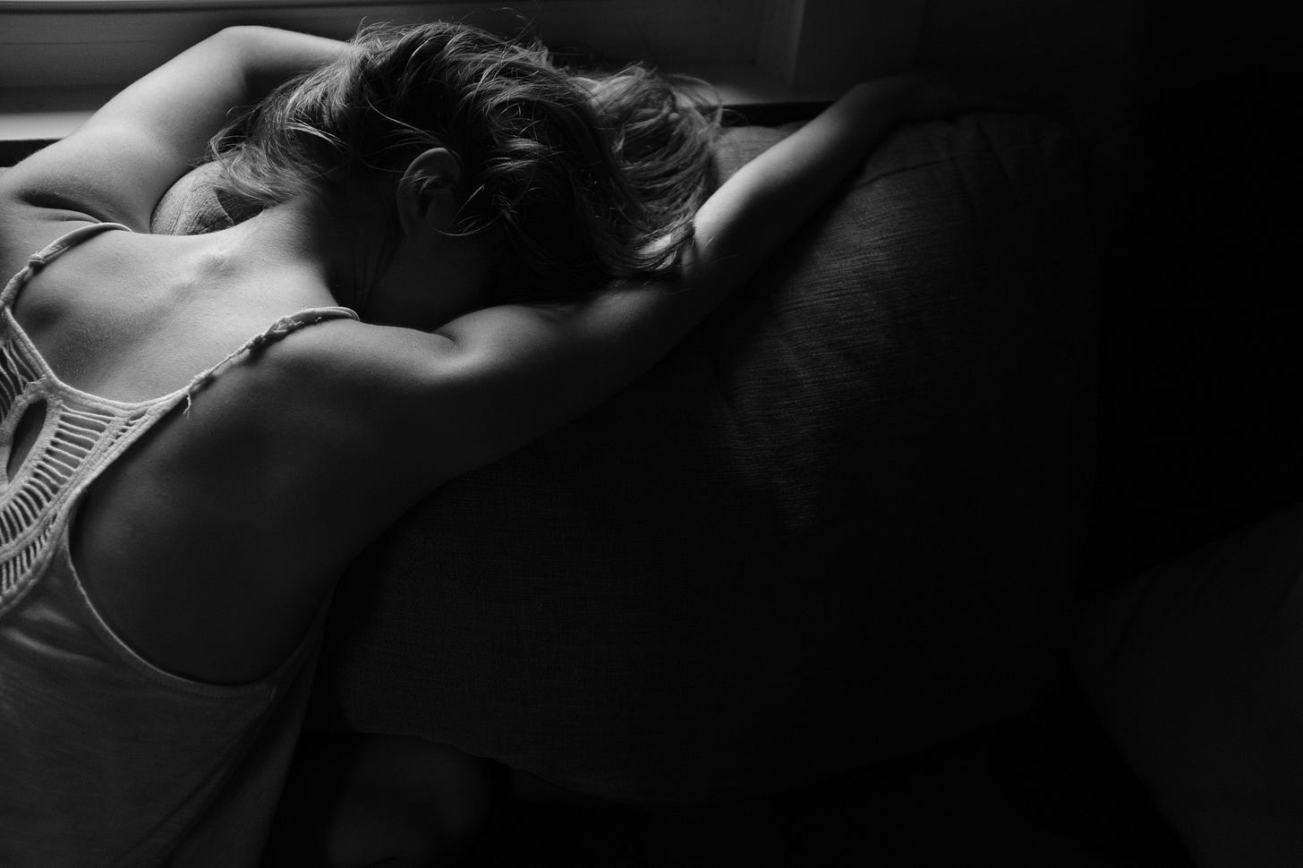 Black and white image of a woman lying with her head in her arms for article by Larry G. Maguire