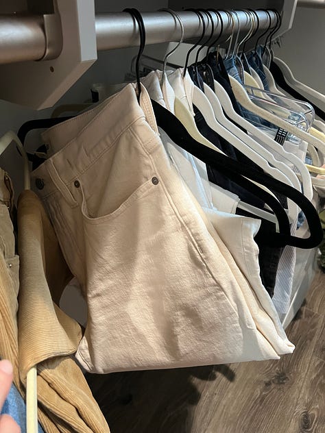 Jeans and sweaters hanging in my closet.