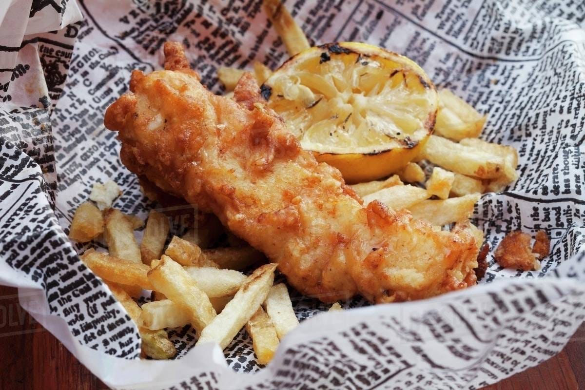 Fish and Chips Wrapped in Newspapers, Traditional Food on a Plate in ... Fish and Chips Wrapped in Newspapers, Traditional Food on a Plate in ...