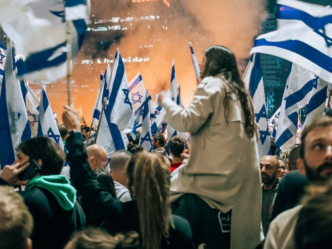 a large group of people holding flags in front of a crowd