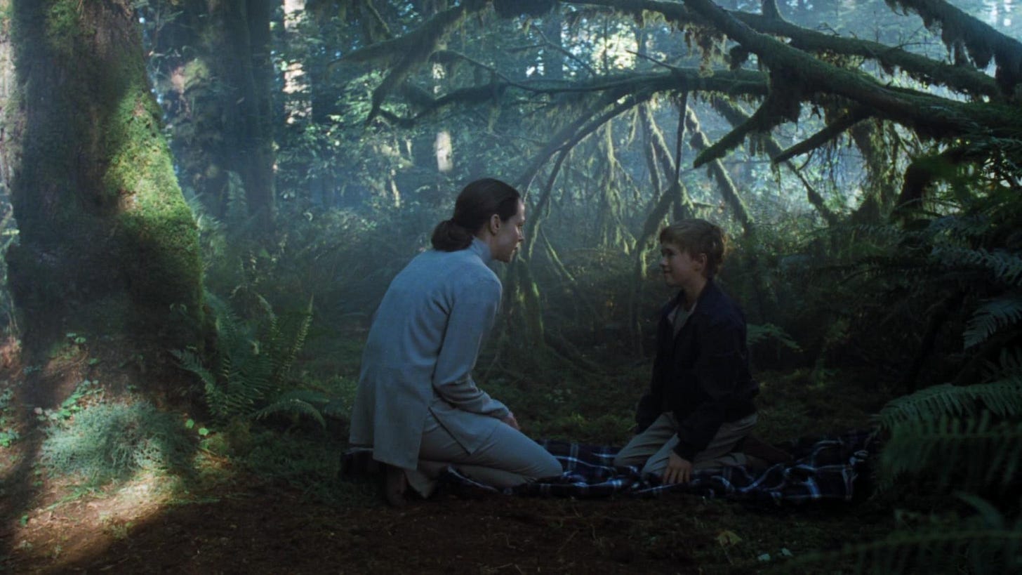 A human mother and a realistic robot child cry in the forest