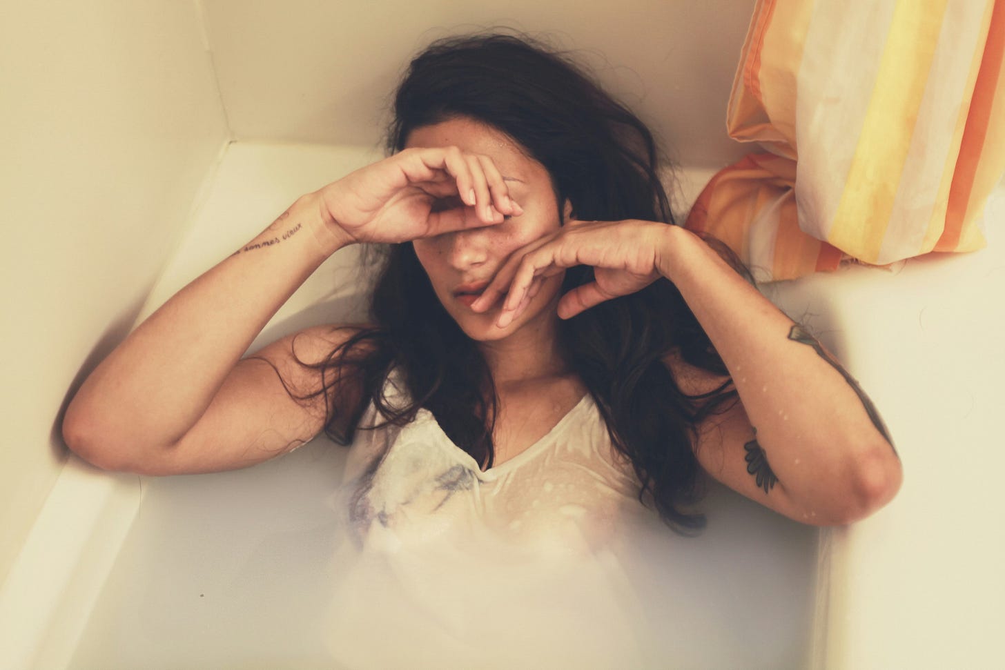 A woman in the bathtub with clothes on