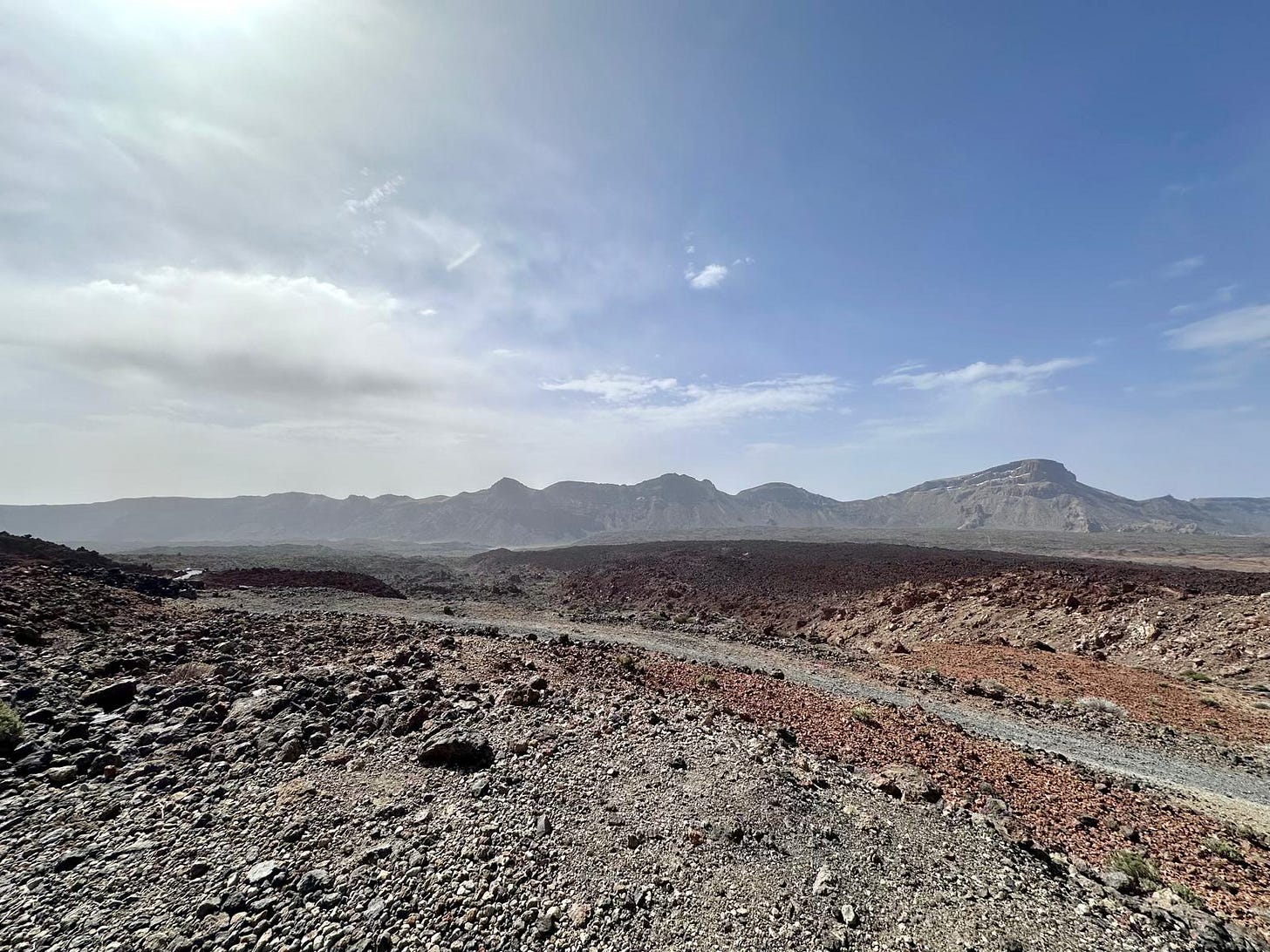 The volcanic landscape of Montana Blanca in Tenerife, orange rocky hills stretching into the distance under a clear sky.