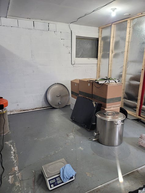 A green car garage door. An grow tent with empty racks. An empty garage with boxes and things.