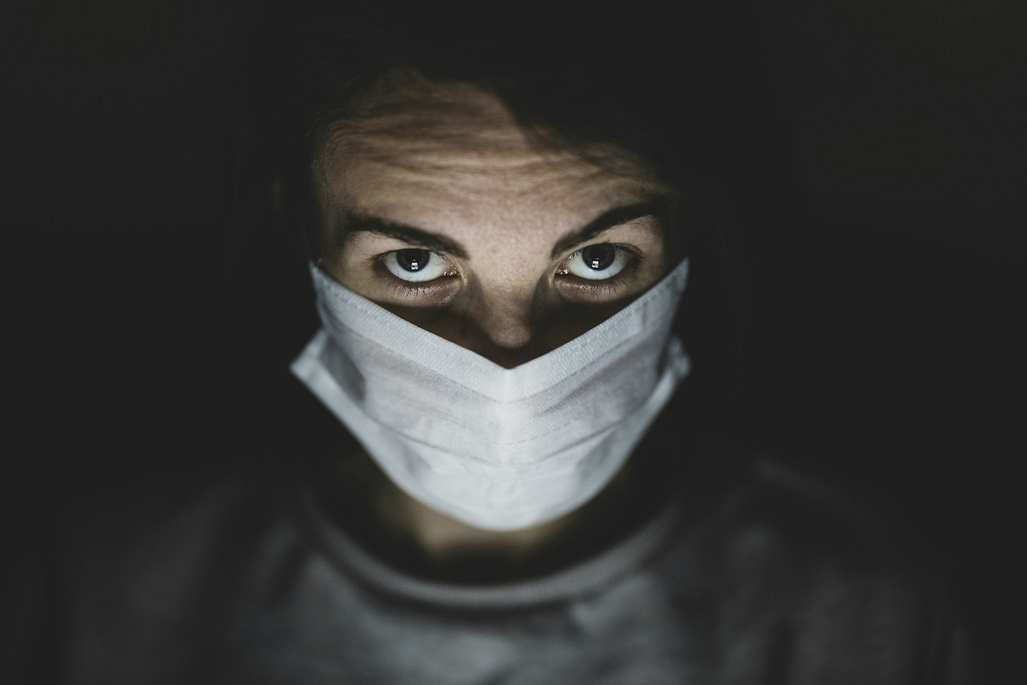 Person looking up above a surgical mask. Photo by Engin Akyurt on Unsplash