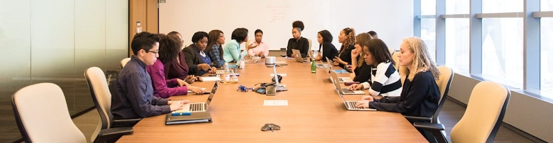 people having meeting on rectangular brown table people having meeting on rectangular brown table