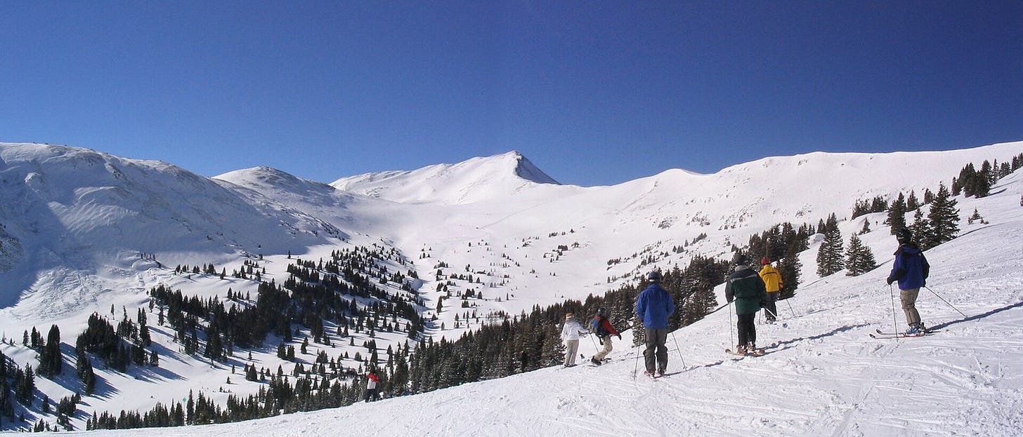 Skiers above Copper Bowl at Copper Mountain on a bluebird day