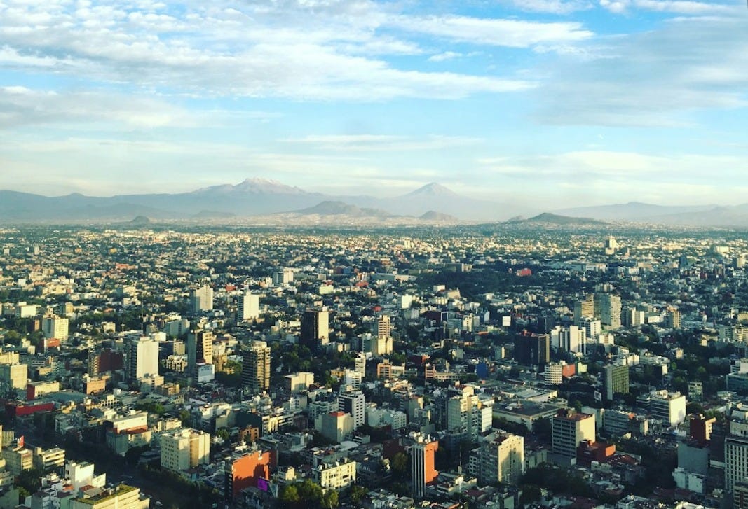 aerial photo of concrete buildings under white clouds at daytime