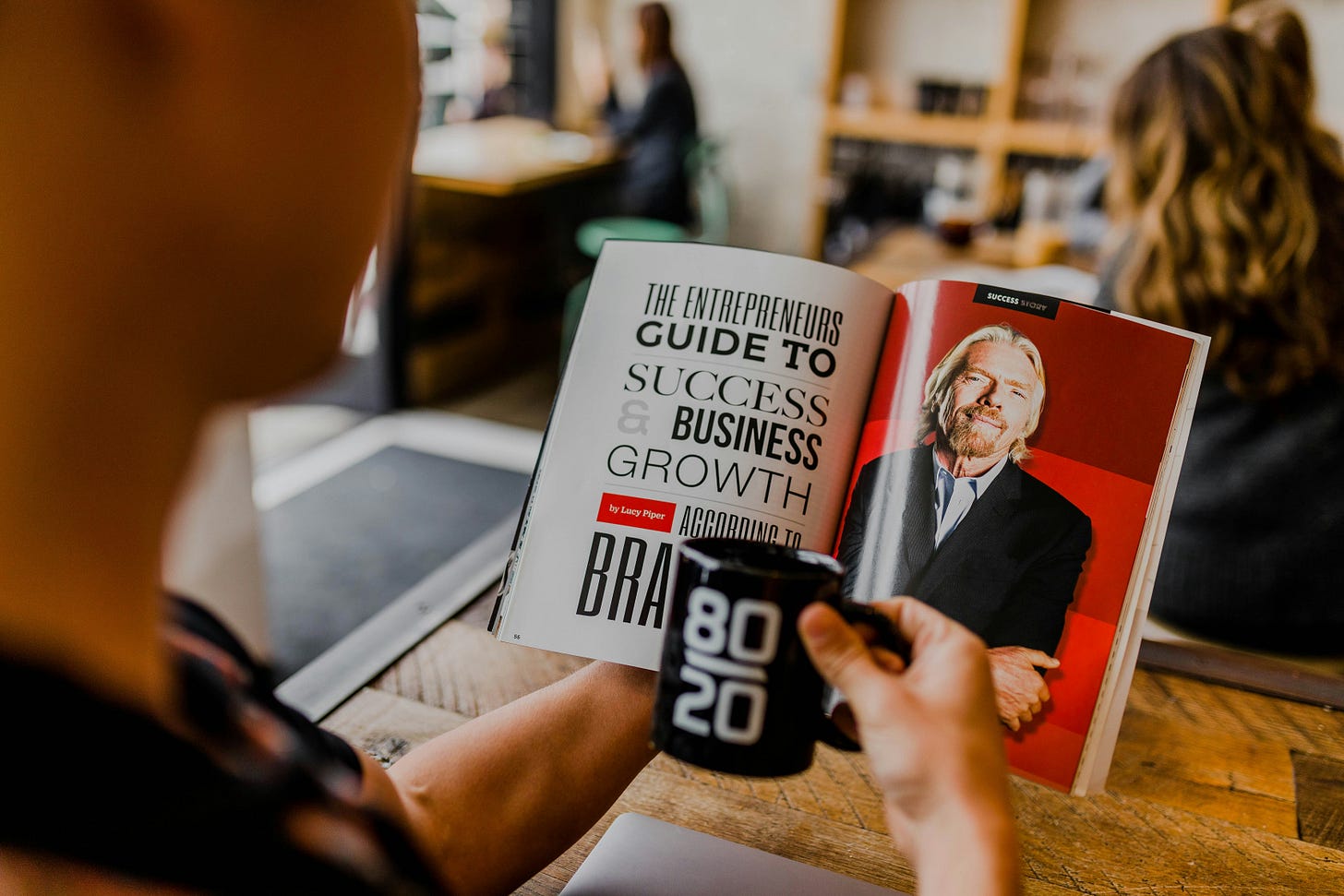 Man reading branding book with photo of Richard Branson