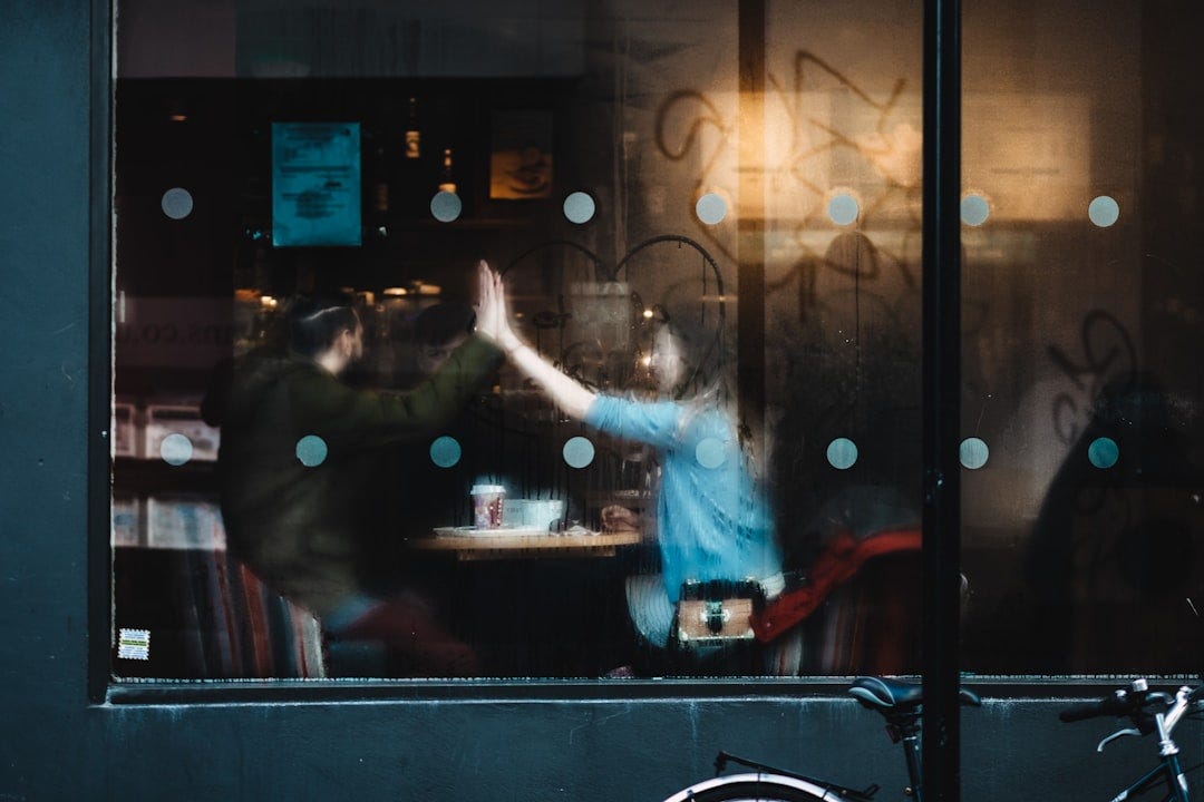 man and woman clapping each other hands inside the cafe man and woman clapping each other hands inside the cafe
