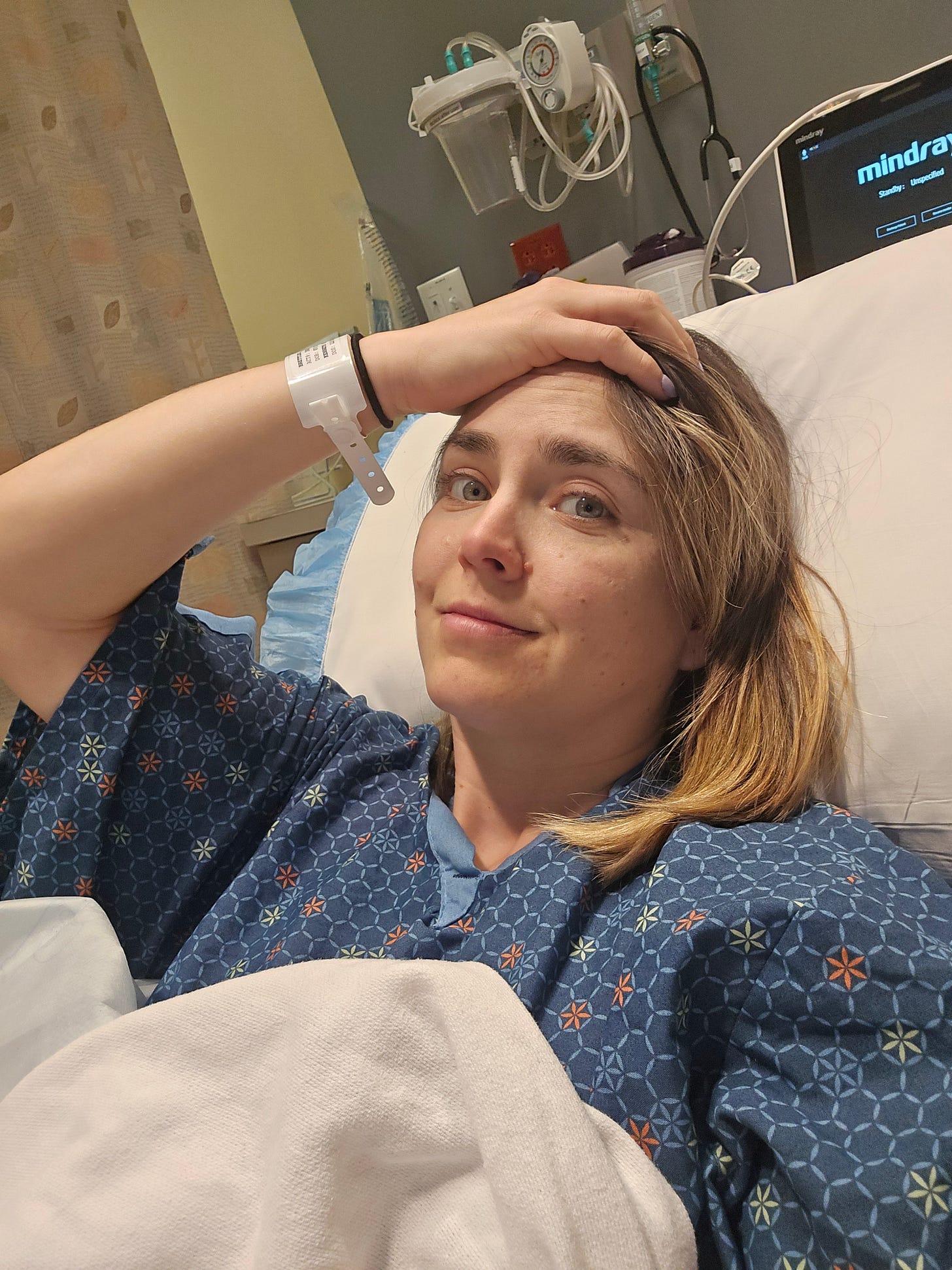 Cassidy wearing a hospital gown, laying in a hospital bed after waking up from surgery Cassidy wearing a hospital gown, laying in a hospital bed after waking up from surgery