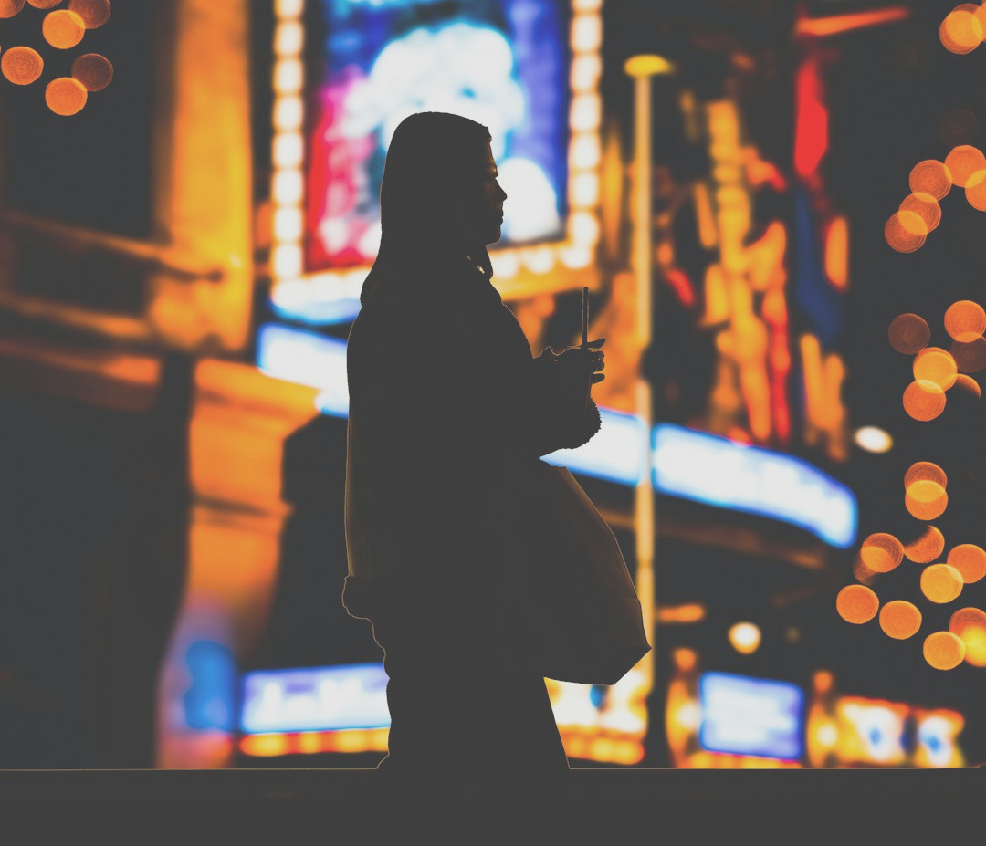 A person standing in front of a building at night