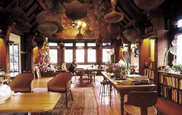The artist Ruth Asawa in her living room, around 1995, with clusters of her looped wire sculptures dangling from the rafters.