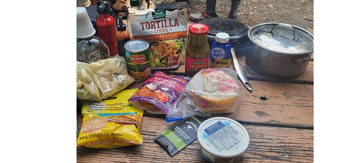 A four-photo sequence of campfire chicken enchiladas: raw ingredients on a picnic table, the assembled pan topped with shredded cheese, the bubbling finished dish, and a final serving on a plate.