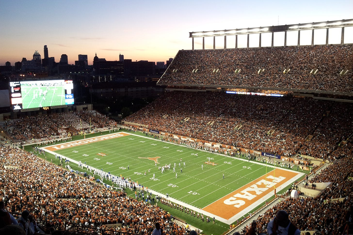 Night game at Darrell K Royal Texas Memorial Stadium with the Austin skyline
