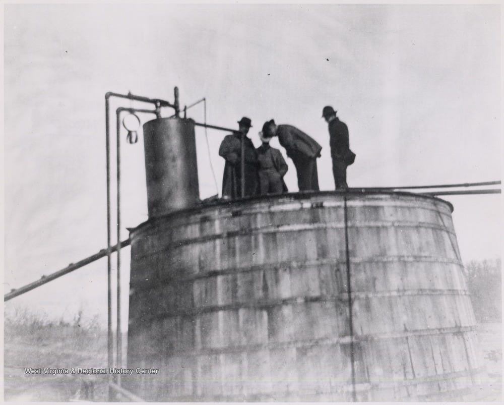 Oil Workers Examining an Old Wooden Oil AST